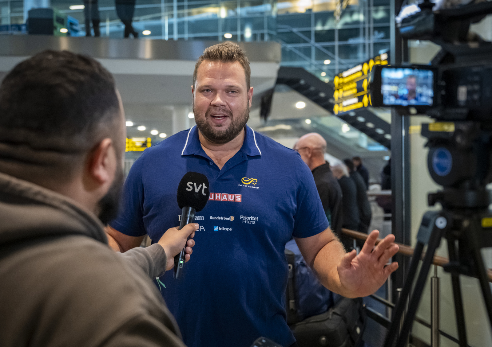 Alltid glädjespridaren, På arenan, eter att seern är säkrad, vid hemkomsten. Daniel Ståhl tänker alltid på omgivningen. Här intervjuas Daniel när han han anländer till Kastrups flygplats efter sitt VM-guld i Japan. Foto: Johan Nilsson / TT
