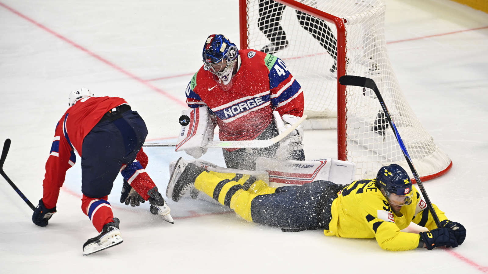 Tre Kronor på fall. Sveriges Joel Persson utgör inget hot liggandes framför Norges målvakt Henrik Haukeland. Foto: Anders Wiklund / TT