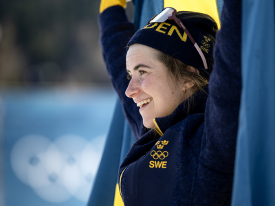 Ebba Andersson får en kort stund med sig själv och, inlindad i flaggan, och njuta av känslan. Foto: Christine Olsson / TT