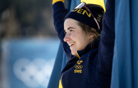 Ebba Andersson får en kort stund med sig själv och, inlindad i flaggan, och njuta av känslan. Foto: Christine Olsson / TT