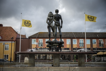 Vardagen börjar återkomma i Sölvesborg. Här ses skulpturgruppen Ask och Embla på Stortorget i Sölvesborg flankerad av Mjällbys klubbflagga Foto: Johan Nilsson / TT
